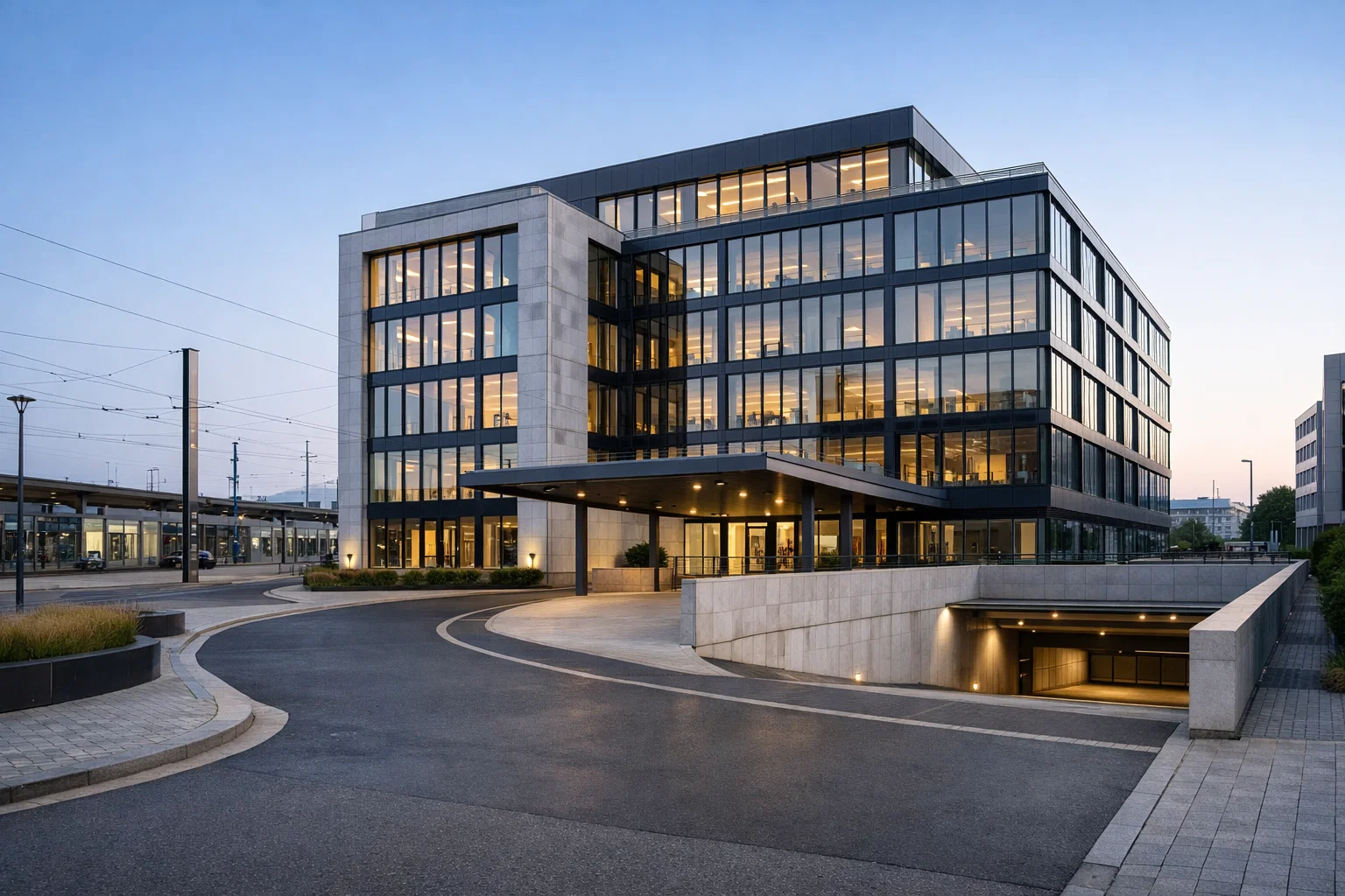 Façade d’un immeuble de bureaux proche d’une gare, avec accès parking.